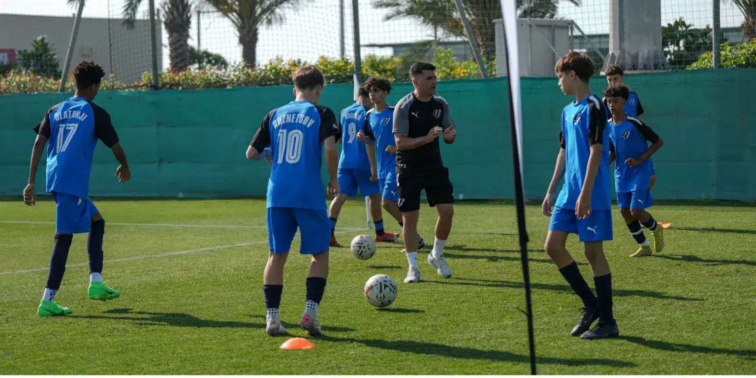 A group of young men playing soccer on a field during the Mina Cup tournament.