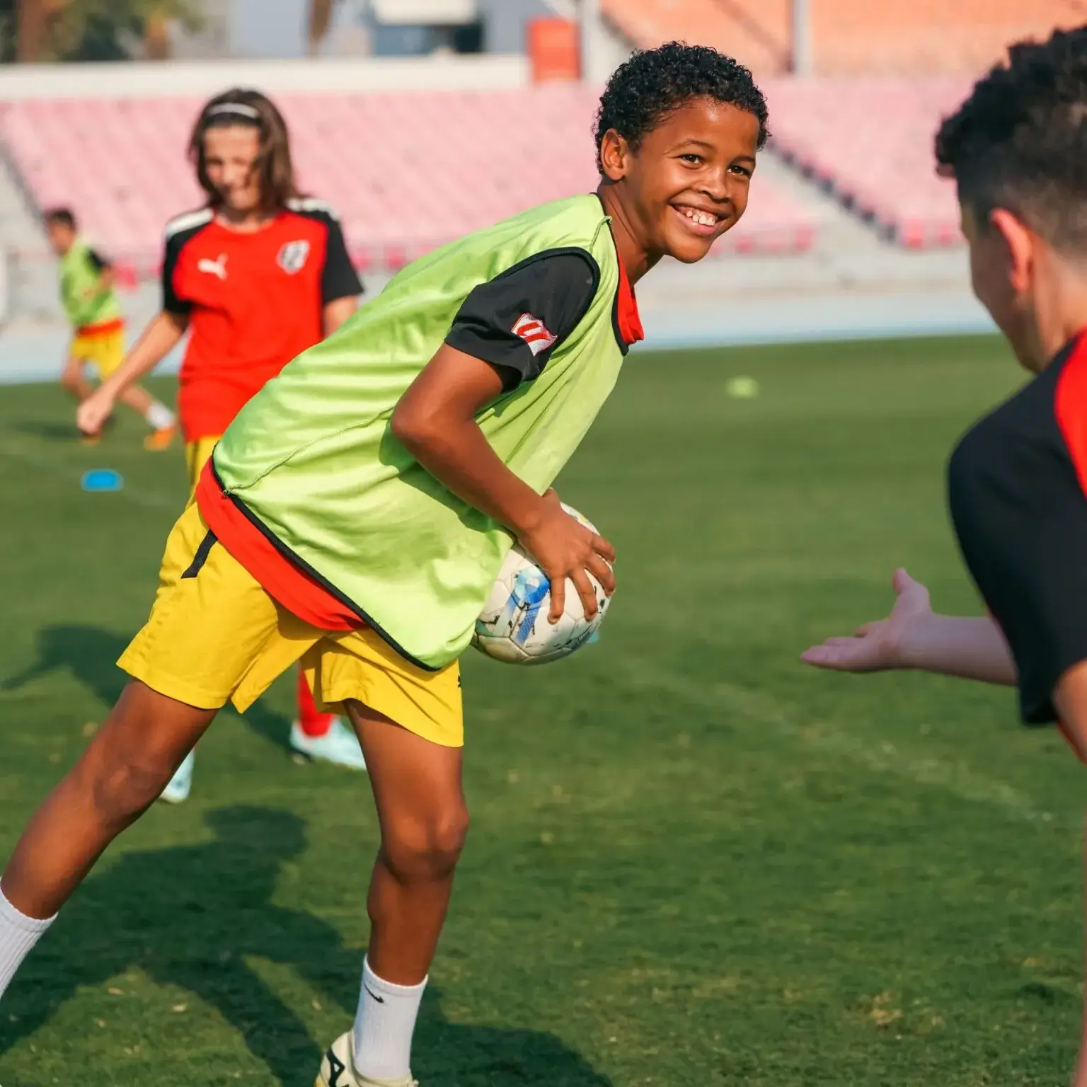 A young boy happily playing football | IBER Cup.