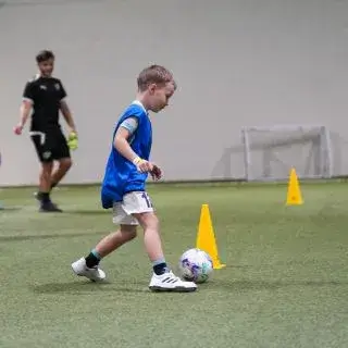 A young participant hones his skills during a football summer camp in Dubai at the LaLiga Academy