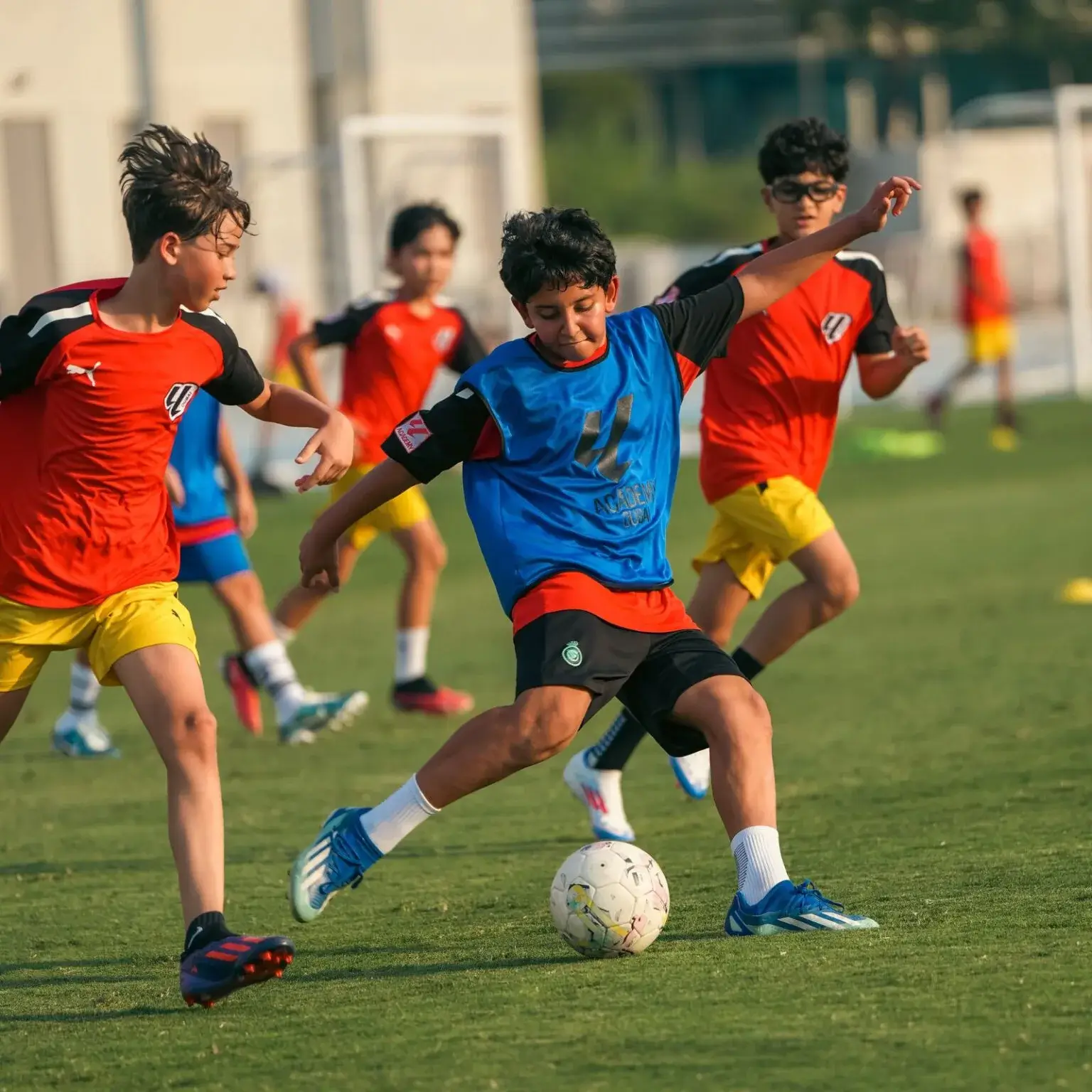 Boys playing football on field during last training session before IBER Cup.