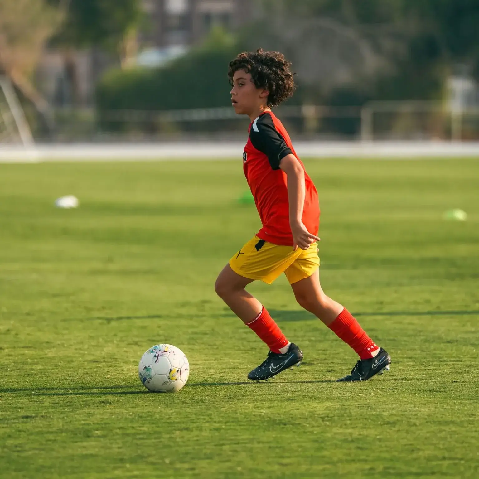 Smiling young boy enjoying soccer practice ahead of IBER Cup tournament.