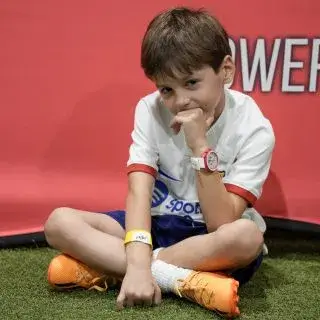 Summer football camps |A thoughtful young boy sitting on the ground.