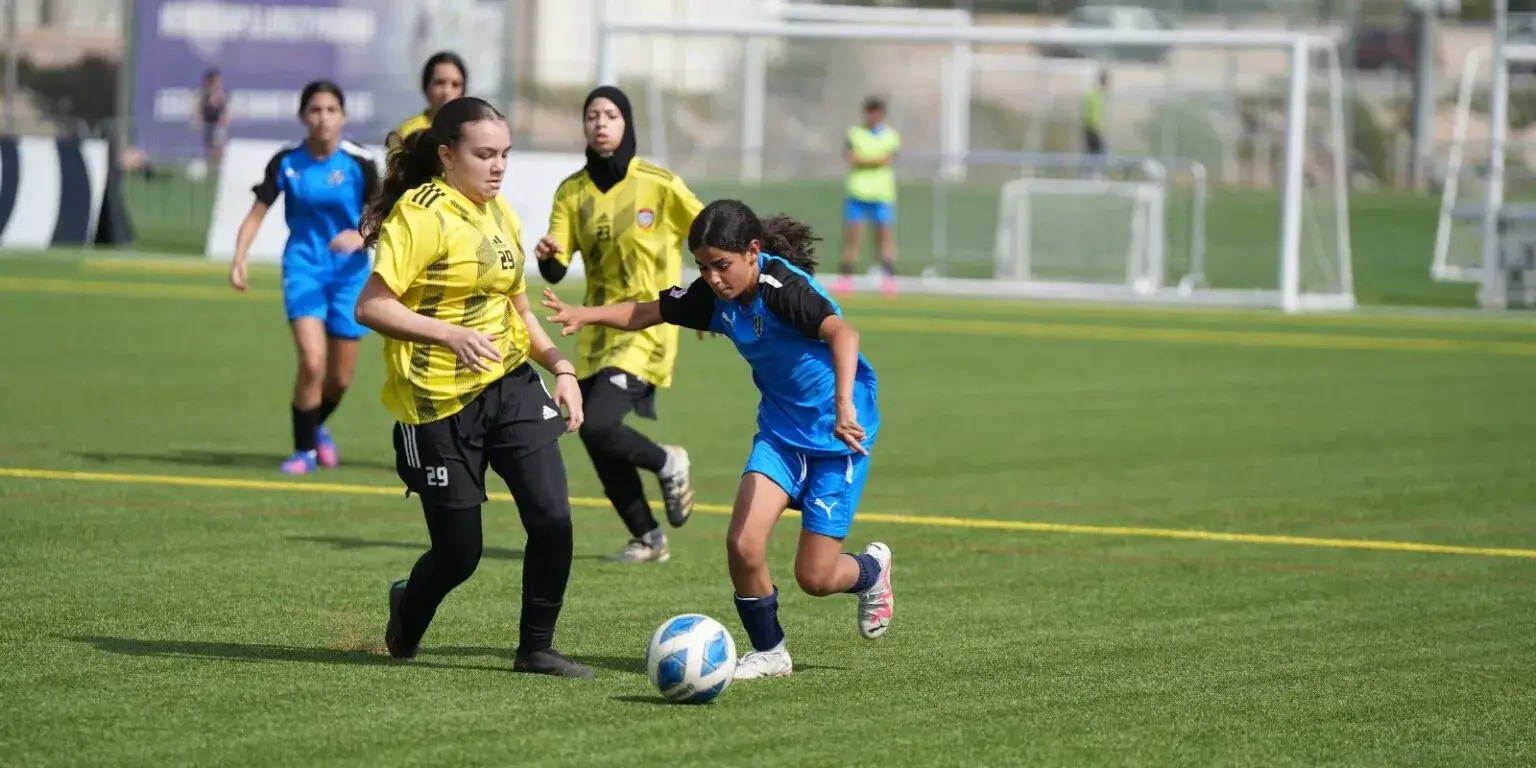 DOFA football Season 2023 | Girls in blue and yellow uniforms engaged in a game