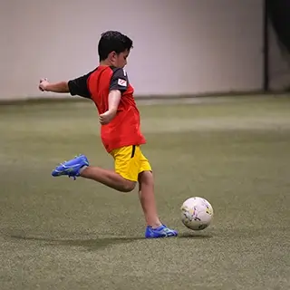 Young Boy Playing Soccer at Kids Football Academy