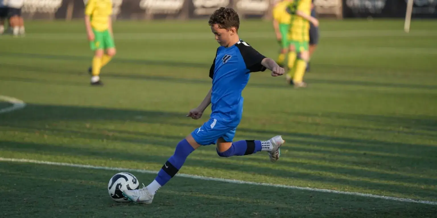 soccer player in blue and white uniform kicking a ball during Mina Cup 2024.