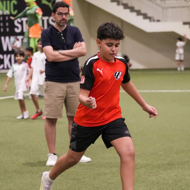 A parent of a player in LaLiga Academy Dubai watching his child learn football in Dubai Sports City