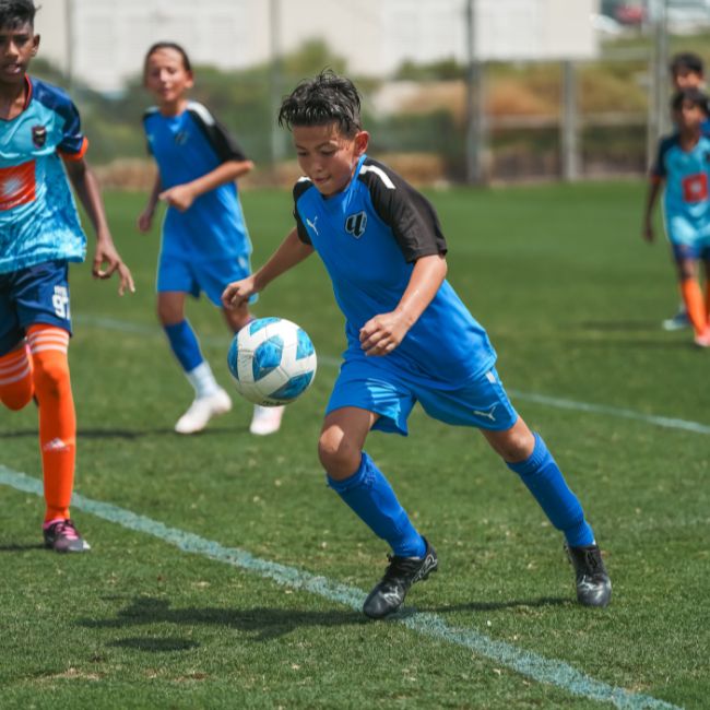 Kids from LaLiga Academy Dubai playing in a competitive match in DOFA