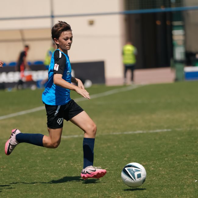 A LaLiga Academy Dubai player dribbling the ball during a match in DOFA tournament