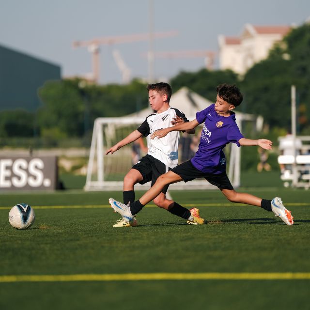 A player of LaLiga Academy Dubai's HPC Squad tackling the football away from his opposition during a match in DOFA league at ISD Dubai Sports City