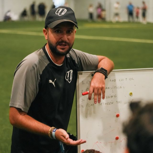 Coach Manel Ramon explaining game tactics to his U12 LaLiga Academy Dubai Advanced Boys Team during a DOFA League match in ISD's indoor football pitch