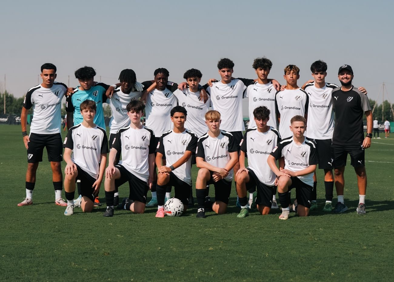 Players of LaLiga Academy Dubai's HPC Squad with coach Manel Ramon posing for a team photograph before their DOFA league game