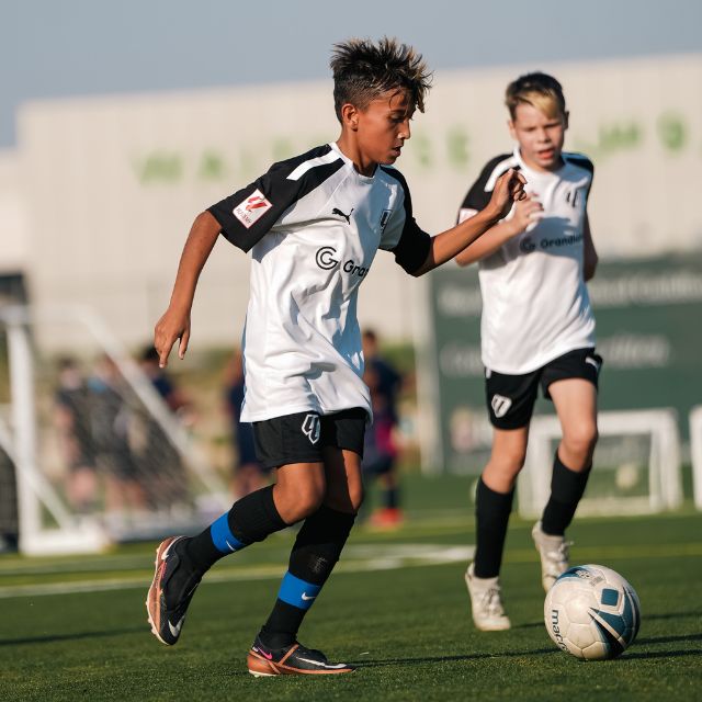 Two boys who play for LaLiga Academy Dubai's HPC Squad moving forward with the ball during a match in DOFA league at ISD Dubai Sports City