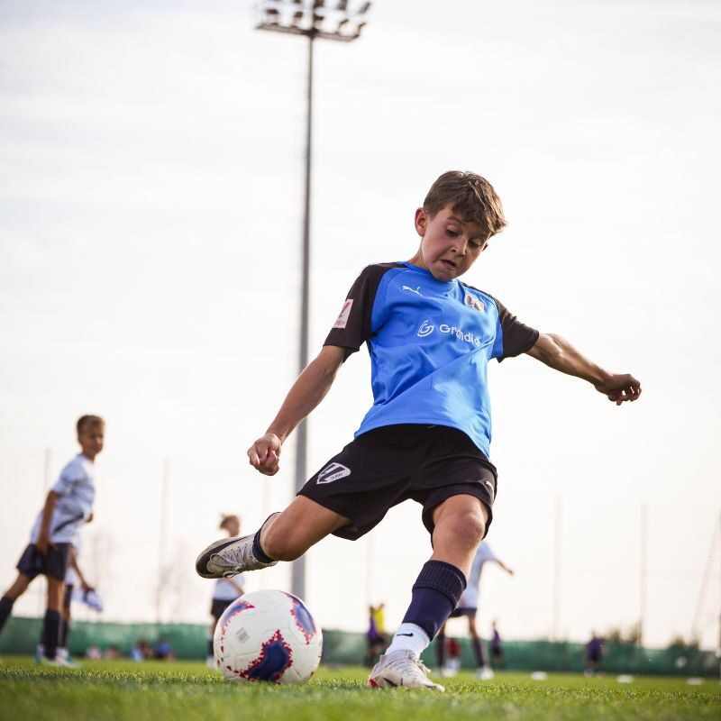 A young football player taking a free kick for la liga dubai in Dubai Sports City