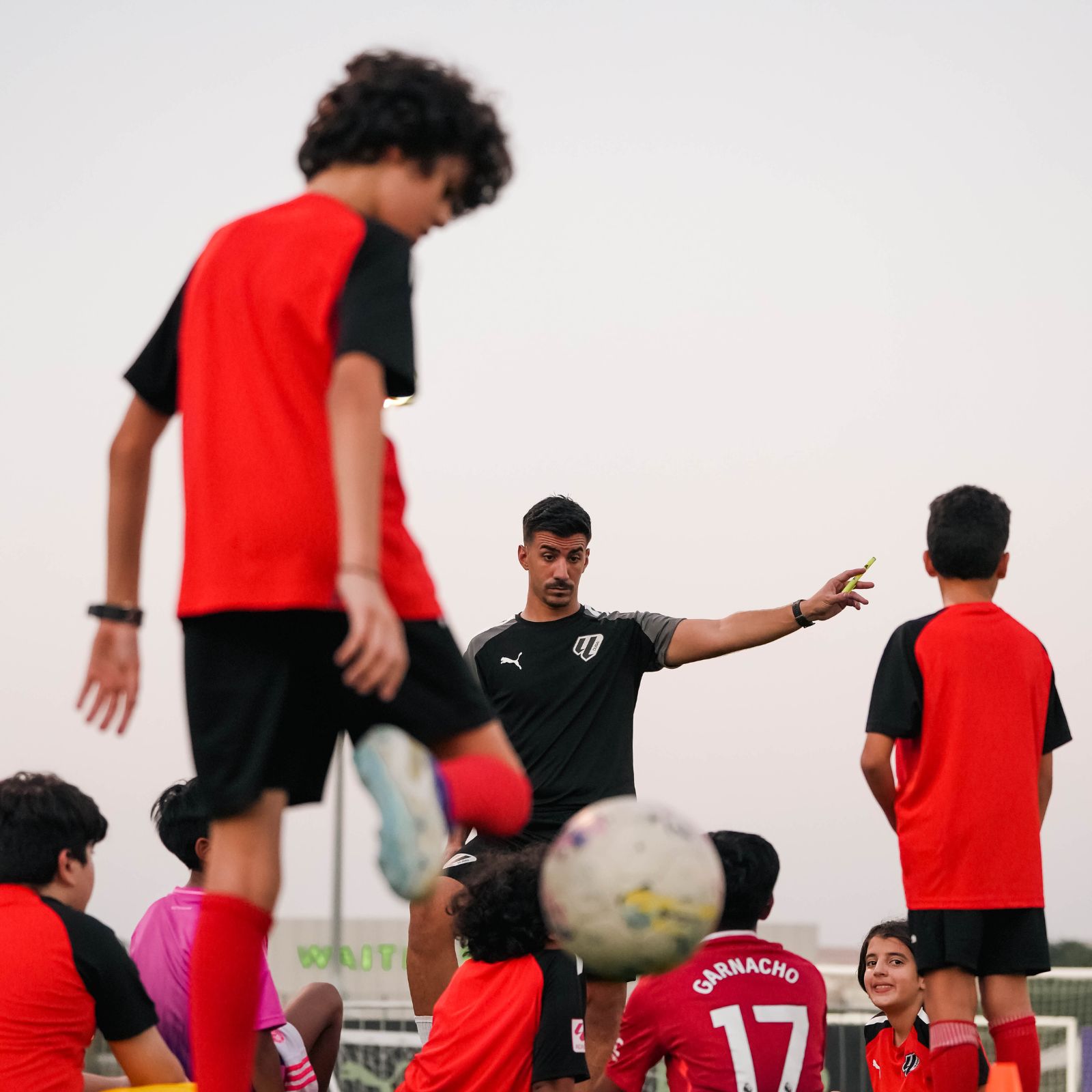 A coach teaching football strategy at a Football coaching near you at Dubai Sports City at LaLiga Academy Dubai
