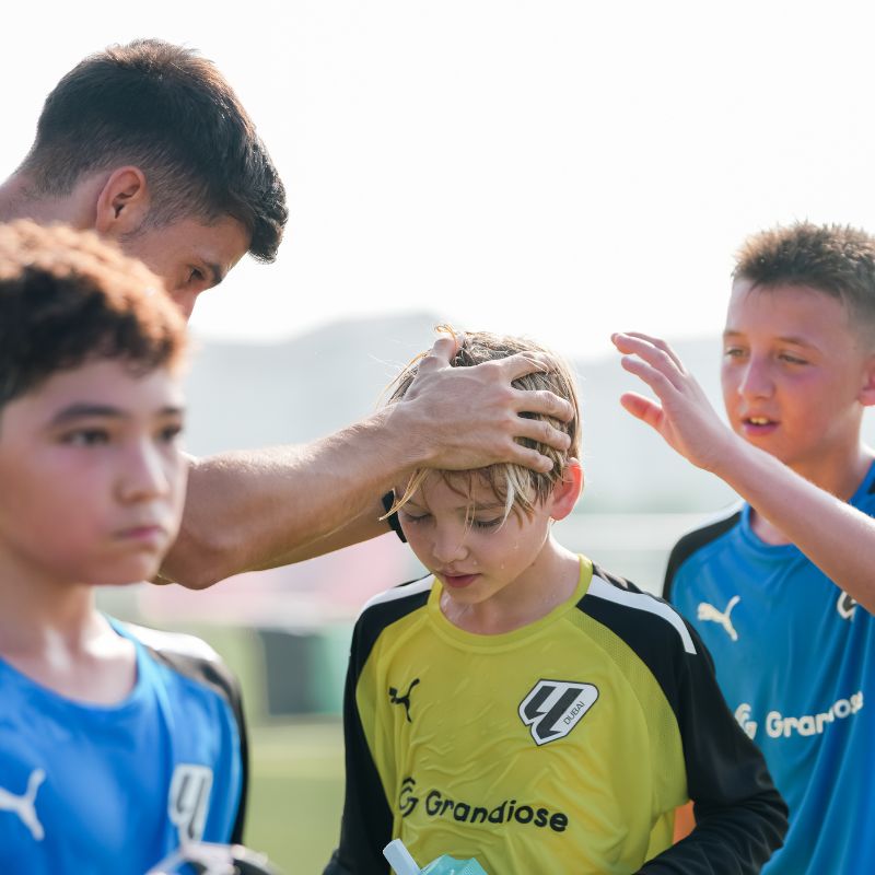 A-football-coach-congratulating-a-young-boy-after-he-did-well-during-football classes in Dubai at laliga-academy-Dubai-Sports-City