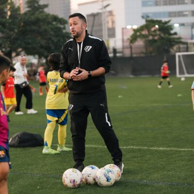 A football coach during football classes for kids at laliga academy dubai in dubai sports city
