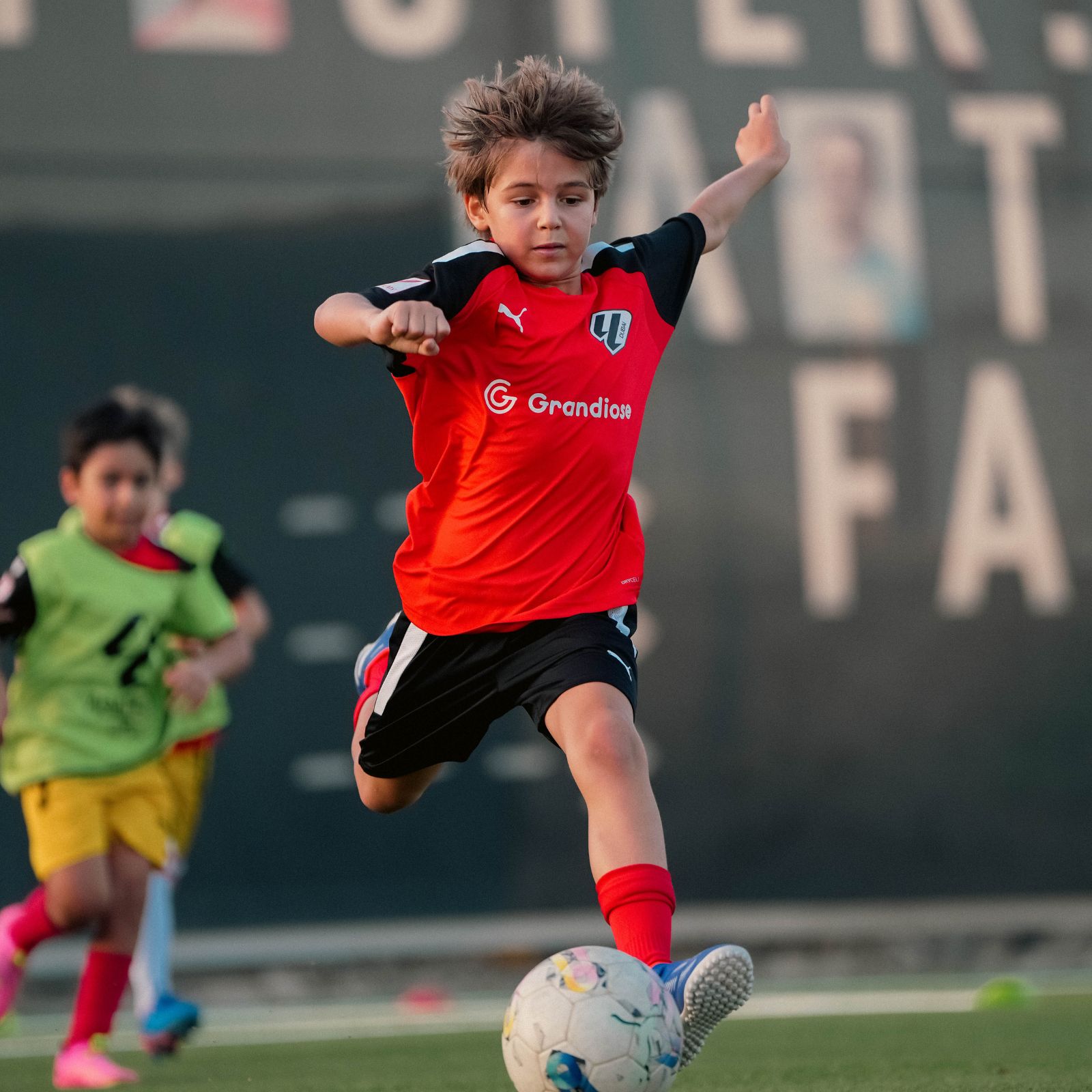 Young boys during a football drill at their Football Coaching in Dubai Sports City